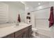 Bright bathroom features a tub with tile surround, neutral walls, and vanity with solid surface countertop at 8108 E Paloma Ave, Mesa, AZ 85212