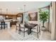 Well-lit dining room with dark wood table, six chairs, decorative rug and accents, and view into kitchen at 8108 E Paloma Ave, Mesa, AZ 85212