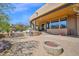 Expansive backyard featuring a built-in grill, fire pit, covered patio, and lush landscaping at 8154 E Tecolote Cir, Scottsdale, AZ 85266