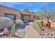 Front Entrance with desert landscaping, pottery, a brick walkway, and wooden door at 8154 E Tecolote Cir, Scottsdale, AZ 85266