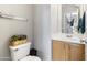 Half bathroom featuring a toilet and sink and mirror with natural-tone cabinets at 891 E Windsor Dr, Gilbert, AZ 85296