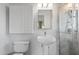 Modern bathroom with a glass enclosed shower, pedestal sink, and patterned wall storage at 1009 E Bethany Home Rd, Phoenix, AZ 85014