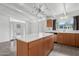 Kitchen island featuring a white countertop and custom wood cabinets plus sink area at 1009 E Bethany Home Rd, Phoenix, AZ 85014