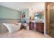 Luxurious bathroom featuring a freestanding tub, stone floors, and and sinks at 1040 E Osborn Rd # 1801, Phoenix, AZ 85014