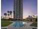 A high-rise building overlooks a pool and lounge area with palm trees at sunset at 1040 E Osborn Rd # 1801, Phoenix, AZ 85014