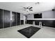 Finished bonus room with gray and black walls, ceiling fan, television and two white stools at 10520 W Patrick Ln, Peoria, AZ 85383