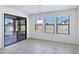 Bright dining area features sliding glass door access to the patio and multiple windows with horizontal blinds at 10520 W Patrick Ln, Peoria, AZ 85383