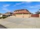 Two-story home with a terracotta roof and a three-car garage, with xeriscaping at 10520 W Patrick Ln, Peoria, AZ 85383