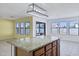 Kitchen island with granite countertop and a view of the sunlit dining area at 10520 W Patrick Ln, Peoria, AZ 85383