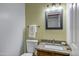 Charming powder room with granite countertop, framed mirror, decorative lighting, and a convenient toilet at 10520 W Patrick Ln, Peoria, AZ 85383