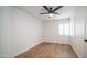 A bright, simple bedroom with hardwood floors and a window with plantation shutters at 10957 E Hope Dr, Scottsdale, AZ 85259