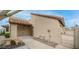 Exterior covered entry with gate, red-tiled roof, desert landscaping and beige stucco exterior at 10957 E Hope Dr, Scottsdale, AZ 85259