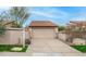 Beige two car garage and private driveway with a red-tiled roof surrounded by desert landscaping at 10957 E Hope Dr, Scottsdale, AZ 85259