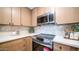 Close-up of a modern kitchen with stainless steel oven and cooktop, stylish backsplash, and wood cabinets at 10957 E Hope Dr, Scottsdale, AZ 85259