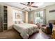 Cozy bedroom featuring a Murphy bed, ceiling fan, and built-in shelving for storage and decor at 115 E Piping Rock Rd, Phoenix, AZ 85022