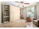 Spacious bedroom with built-in shelving and a large window providing ample natural light at 115 E Piping Rock Rd, Phoenix, AZ 85022