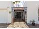 Inviting gated entry featuring decorative wrought ironwork and tiled roof detail on a light colored house at 115 E Piping Rock Rd, Phoenix, AZ 85022