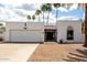 Charming single-story home boasts a pristine white exterior, low maintenance landscaping, and desert palms at 115 E Piping Rock Rd, Phoenix, AZ 85022