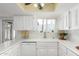 Bright kitchen featuring white cabinets, a double basin sink, and ample counter space at 115 E Piping Rock Rd, Phoenix, AZ 85022