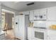 Bright kitchen with white appliances, tile flooring, and a view to the dining room at 115 E Piping Rock Rd, Phoenix, AZ 85022