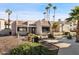 Exterior view of the clubhouse with manicured landscaping and palm trees at 12221 W Bell Rd # 215, Surprise, AZ 85378