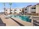 A serene community pool is surrounded by lounge chairs and palm trees at 12221 W Bell Rd # 215, Surprise, AZ 85378