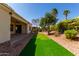 Enjoy this backyard featuring artificial turf, desert landscaping, and a covered patio, great for outdoor enjoyment at 12820 W La Vina Dr, Sun City West, AZ 85375