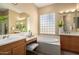 The bathroom features dual sinks, tile flooring, and a bathtub below a window at 12820 W La Vina Dr, Sun City West, AZ 85375