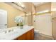 Bathroom vanity with decorative flower display, framed mirror and shower at 12820 W La Vina Dr, Sun City West, AZ 85375