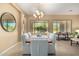 Bright dining area featuring modern chandelier, tile flooring, and views to living spaces at 12820 W La Vina Dr, Sun City West, AZ 85375