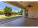 Covered patio area with a ceiling fan, overlooking the lush backyard and beautiful desert landscaping at 12820 W La Vina Dr, Sun City West, AZ 85375