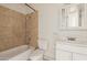 This bathroom features a tub and shower combination, vanity and tile surround, with a white toilet for comfort at 1427 W 6Th Dr, Mesa, AZ 85202