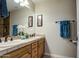 Bathroom with a dual-sink vanity featuring warm wood cabinets and a neutral countertop at 150 N Lakeview Blvd # 1, Chandler, AZ 85225