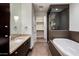 Modern bathroom featuring dual vanity, soaking tub, and glass shower enclosure at 15215 N Kierland Blvd # 633, Scottsdale, AZ 85254