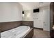 Modern bathroom with a soaking tub, brown tile accents, and a large mirror at 15215 N Kierland Blvd # 633, Scottsdale, AZ 85254