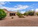 Backyard features a desert landscape and a covered patio at 15850 W Silver Breeze Dr, Surprise, AZ 85374