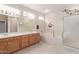 Bright bathroom with double sinks, a soaking tub, separate shower, and travertine flooring at 15850 W Silver Breeze Dr, Surprise, AZ 85374