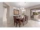 Elegant dining room with a chandelier, art, and a sliding glass door, creating a warm space at 15850 W Silver Breeze Dr, Surprise, AZ 85374