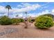 Charming home featuring desert landscaping with various trees, bushes, and a glimpse of blue skies with clouds at 15850 W Silver Breeze Dr, Surprise, AZ 85374