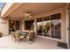 Covered patio with a ceiling fan, a table with six chairs, and desert landscaping in the background at 15850 W Silver Breeze Dr, Surprise, AZ 85374