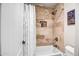 Bathroom tub and shower combination boasting neutral tile and a built-in niche for toiletries at 16388 N 99Th Pl, Scottsdale, AZ 85260