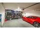 Well-organized garage featuring storage shelves and a vibrant red sports car, optimizing space and appeal at 16388 N 99Th Pl, Scottsdale, AZ 85260