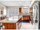 Kitchen island featuring granite countertop, custom wood cabinets, and stainless steel appliances at 16388 N 99Th Pl, Scottsdale, AZ 85260