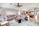 Open-concept living room with plush sectional seating and hardwood floors, adjacent to kitchen at 16388 N 99Th Pl, Scottsdale, AZ 85260