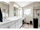 Bright bathroom featuring double sinks, tiled floors, large mirror, vanity, and updated walk in shower at 16388 N 99Th Pl, Scottsdale, AZ 85260