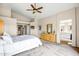 Sun-filled main bedroom featuring vaulted ceilings, neutral walls, carpet floors, dresser, and ensuite bathroom at 16388 N 99Th Pl, Scottsdale, AZ 85260