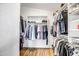 Organized walk-in closet with ample storage, wooden floors, clothing racks, and shelving at 16388 N 99Th Pl, Scottsdale, AZ 85260