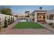 Expansive backyard showcasing a sparkling pool, manicured artificial grass, and privacy landscaping at 16409 N 62Nd Way, Scottsdale, AZ 85254