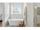 Bright bathroom featuring a standalone tub, towel rack, and frosted window at 16409 N 62Nd Way, Scottsdale, AZ 85254