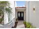 Covered entryway showcasing a black double door framed by desert landscaping and stylish exterior lighting at 16409 N 62Nd Way, Scottsdale, AZ 85254